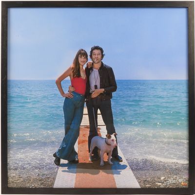 a picture of two people and a dog on a pier