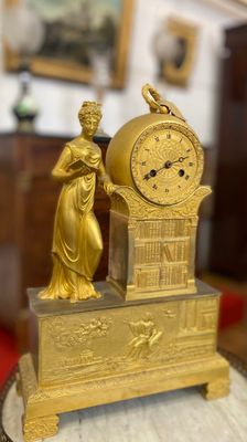 une horloge en or posée sur une table en bois