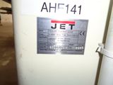 a jet that is sitting on the ground next to a pole