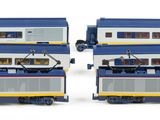 two blue and white double decker trains next to each other