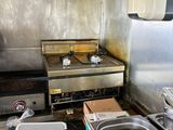 a kitchen with a stove, sink, and other items in it