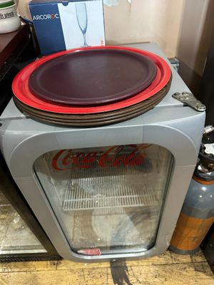un petit réfrigérateur avec une porte vitrée et une assiette posée dessus