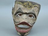 une sculpture en céramique représentant le visage d'un homme, la bouche ouverte