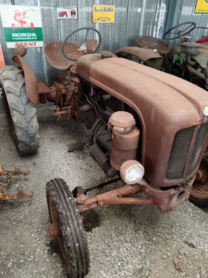 a rusted old tractor sitting in a garage
