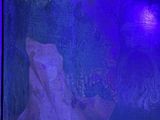 painting of a woman laying on a bed under a purple light