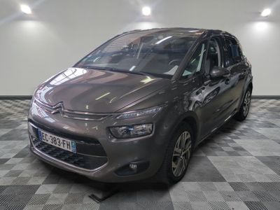 La Citroën grise est garée sur un sol à damier dans un garage