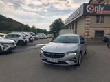 une voiture argentée garée devant un bâtiment dans un parking