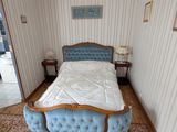 un lit dans une chambre avec un tapis au sol et un lustre