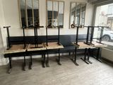 des tables et des bancs dans une pièce dont les murs sont recouverts de miroirs