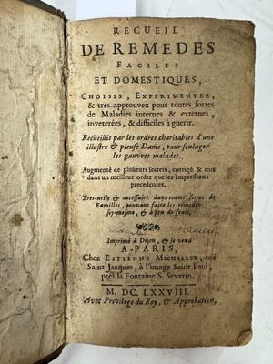 un vieux livre ouvert, sur lequel on peut lire des mots, posé sur une table