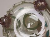 a close up of a glass vase with purple flowers in it