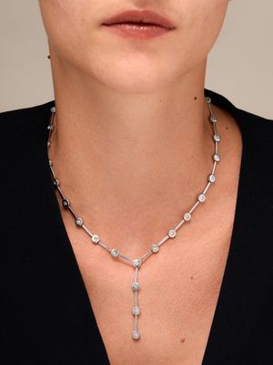 a woman wearing a necklace with a cross on it
