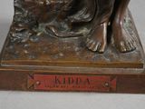 bronze statue of a woman with a dog on a base