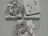 three ear buds and a charger sitting on a table