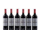 four bottles of wine are lined up on a white surface