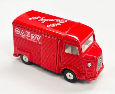 un camion jouet rouge posé sur une surface blanche