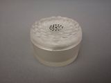 a white container with a flower on it on a table