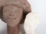 a statue of a woman with a hat next to a statue of a man