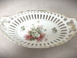 un bol blanc orné de fleurs roses, posé sur une table