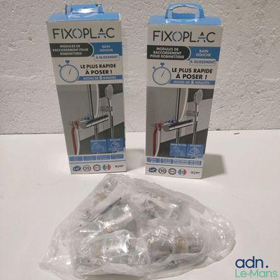 Deux boîtes de Fixoplac sont posées sur une table.