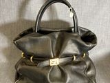 sac à main en cuir noir avec des finitions dorées sur la poignée