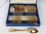 an assortment of gold plated flatware in a blue case