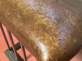 a brown leather bench that is on a red floor