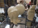 une vitrine en verre sur laquelle sont posées trois figurines d'éléphants