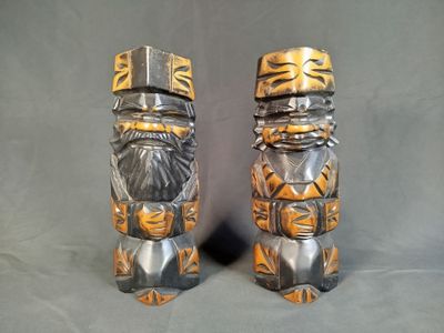 deux totems en bois et en métal sur fond gris