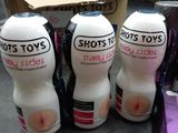 three bottles of shots toys sit on a counter next to a box