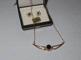 a necklace and earring set in a box on a table