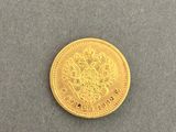 a close up of a gold coin on a gray surface