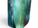 a close up of a glass vase with a green and blue design