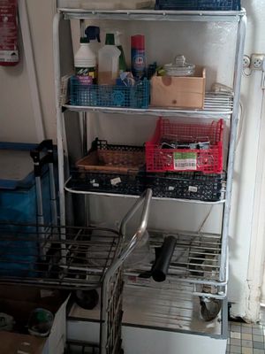 a metal shelf with various items on it in a room