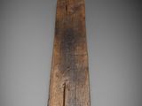 a close up of a wooden paddle on a gray surface