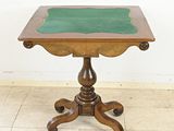 a small wooden table with a green top on a tile floor
