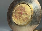 a gold plate with a picture of a woman on it