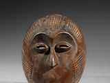 gros plan d'un masque en bois sur une surface blanche