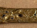 a gold metal object with holes in it