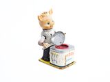 une figurine représentant un chef aux fourneaux avec une poêle