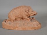 figurine représentant un sanglier posé sur un rocher, sur fond gris