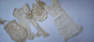 trois vêtements anciens sont disposés sur une surface blanche