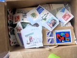 une boîte remplie de timbres et de cartes postales posée par terre