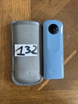 a close up of a camera and case on a wooden table