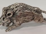 un gros plan sur une figurine en argent représentant un sanglier