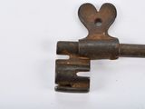 an old rusty key with a heart on it on a white surface