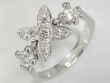 une image d'une bague ornée d'une fleur en diamant sur fond blanc