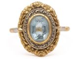 a close up of a gold ring with a blue topaz stone