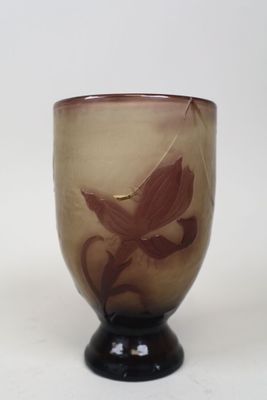 un verre orné d'une fleur, posé sur une surface blanche