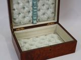une petite boîte en bois contenant un tas de boules blanches